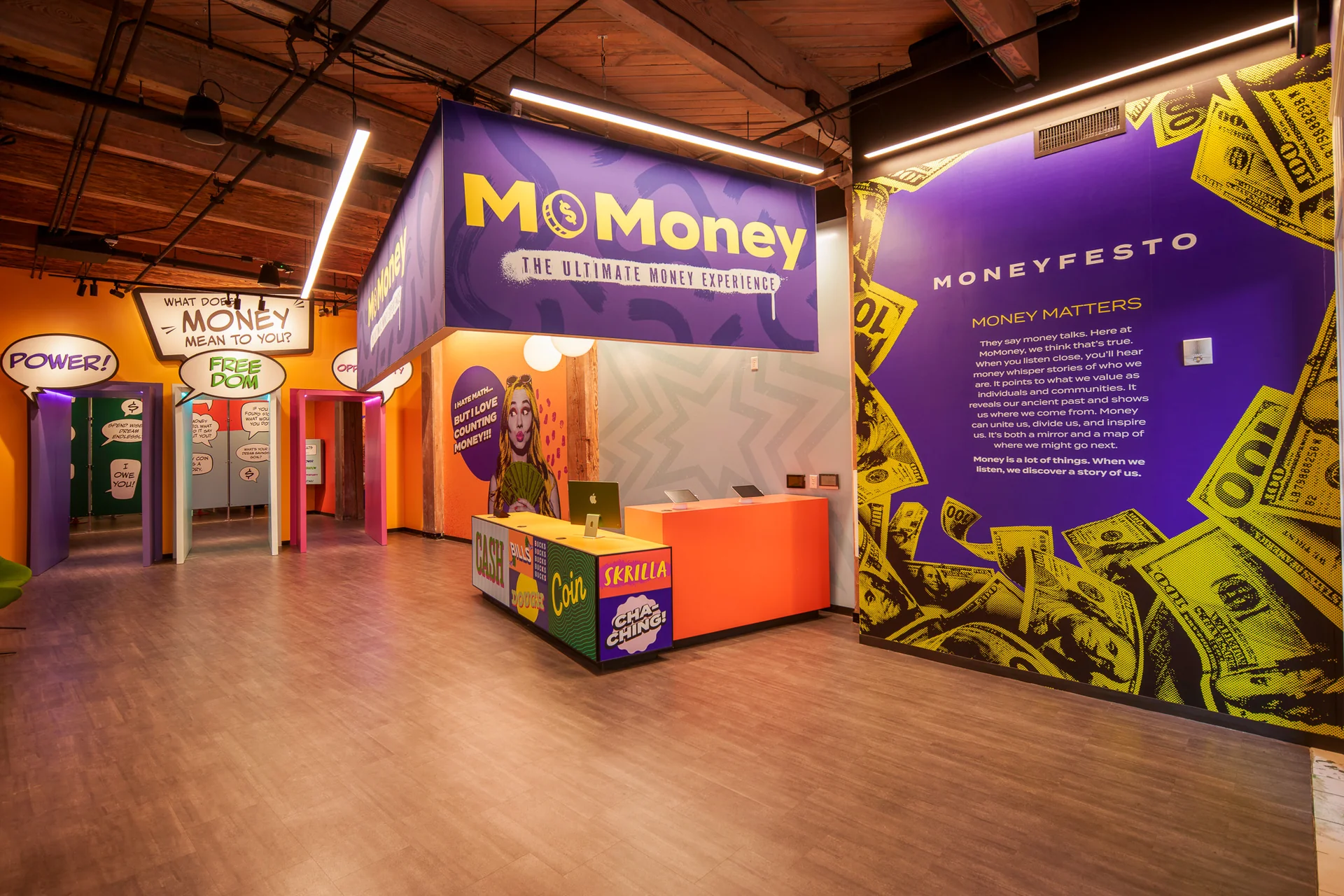 MoFun's lobby: purple signage above an orange reception desk, with speech-bubble doorways and the Moneyfesto wall.